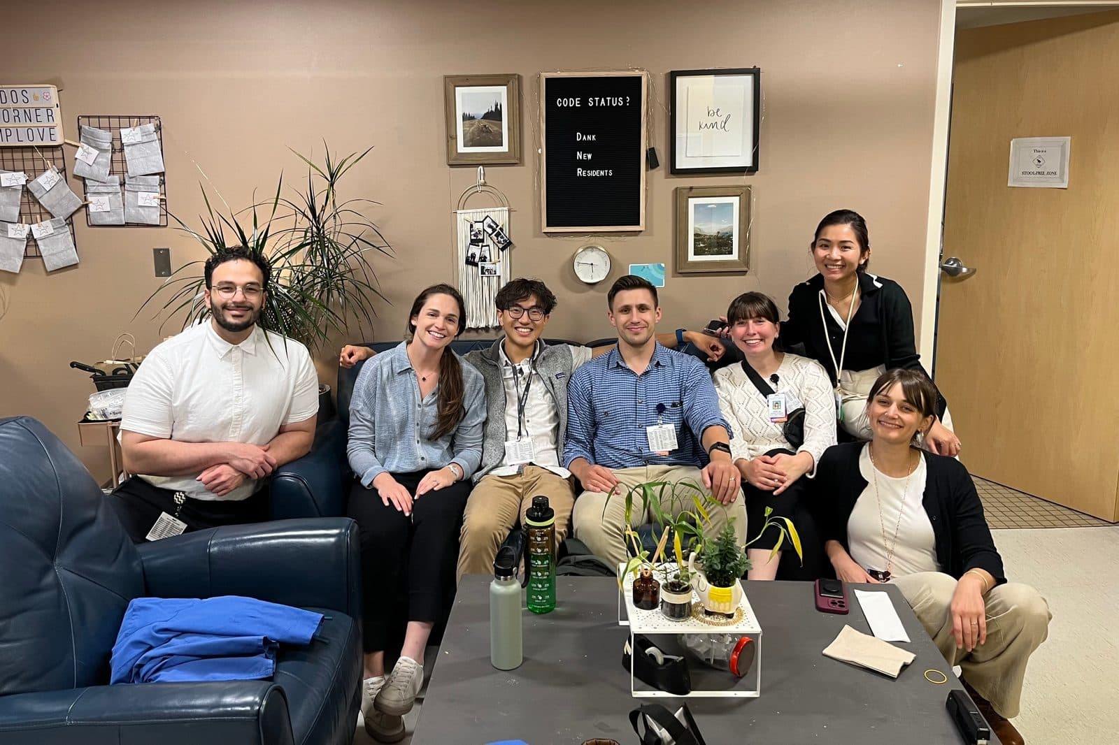 Seven residents from the class of 2027 smiling together on a couch in the FMIS team room