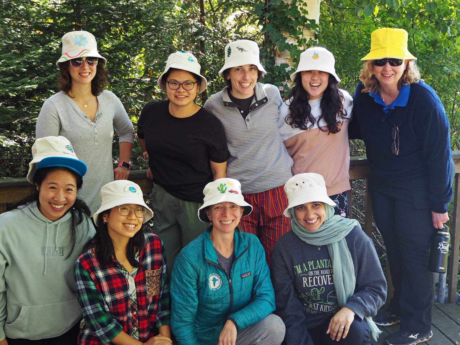 Residents in matching bucket hats posing on a deck