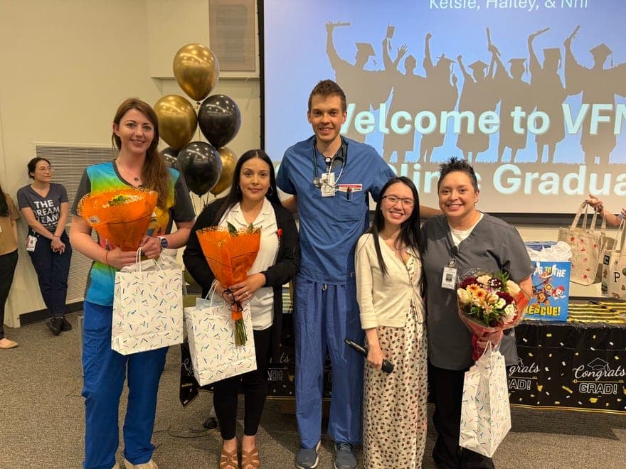 Residents holding flowers and gifts with colleagues at a graduation celebration
