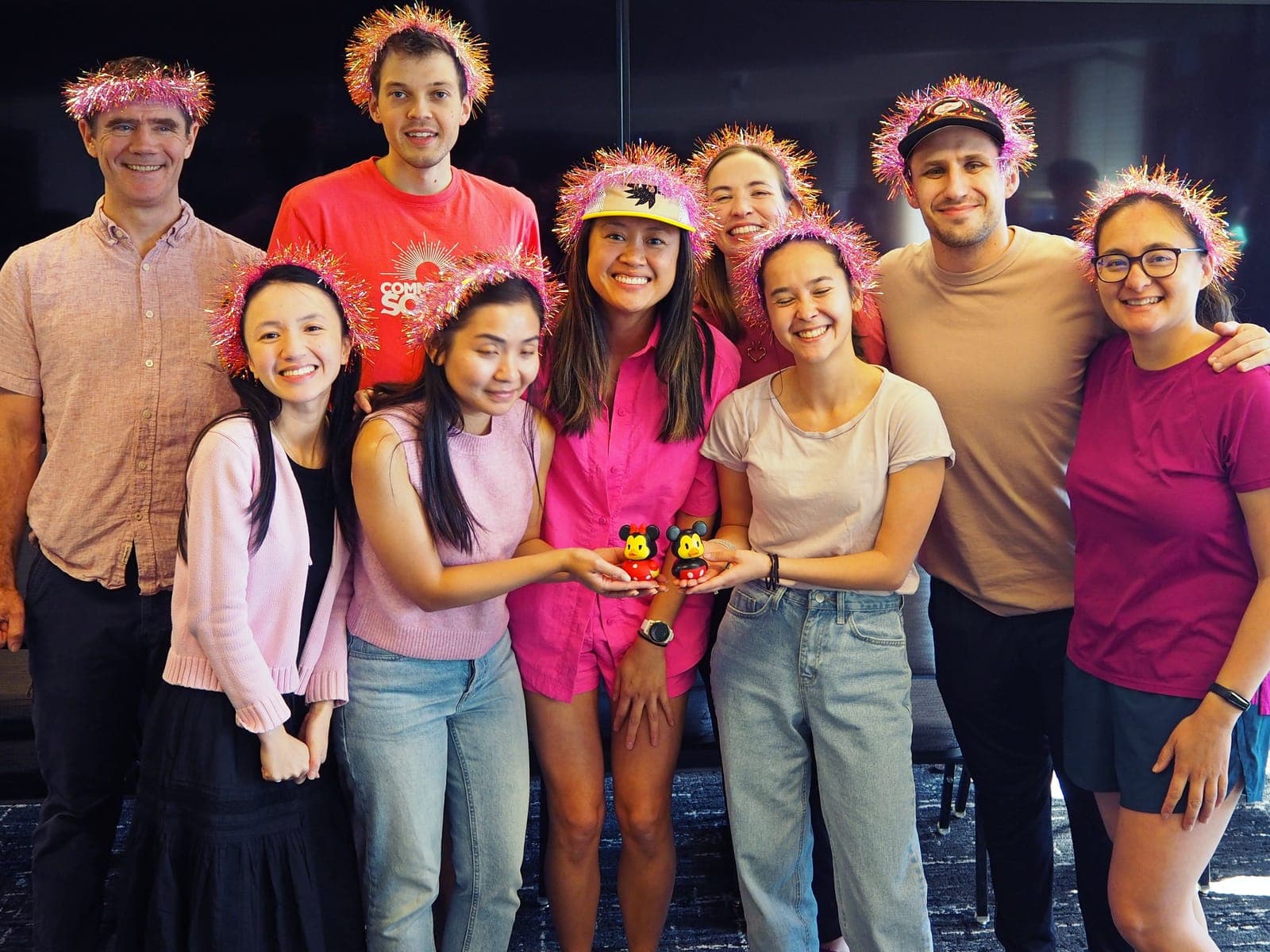 Residents in pink flower crowns smiling together at a party