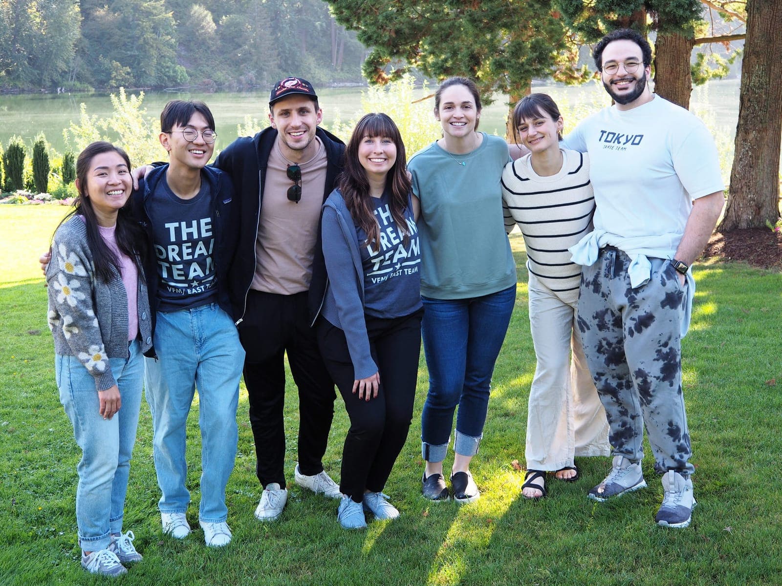 Residents from the class of 2027 standing arm in arm on a lawn by a lake