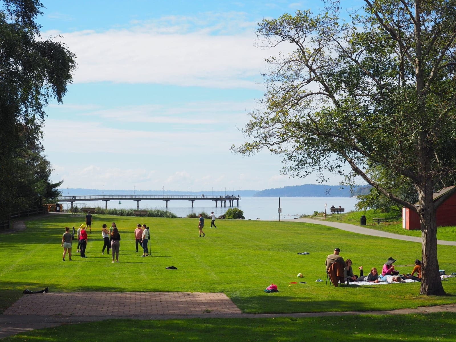 Residents relaxing and playing games on a big lawn beside the water