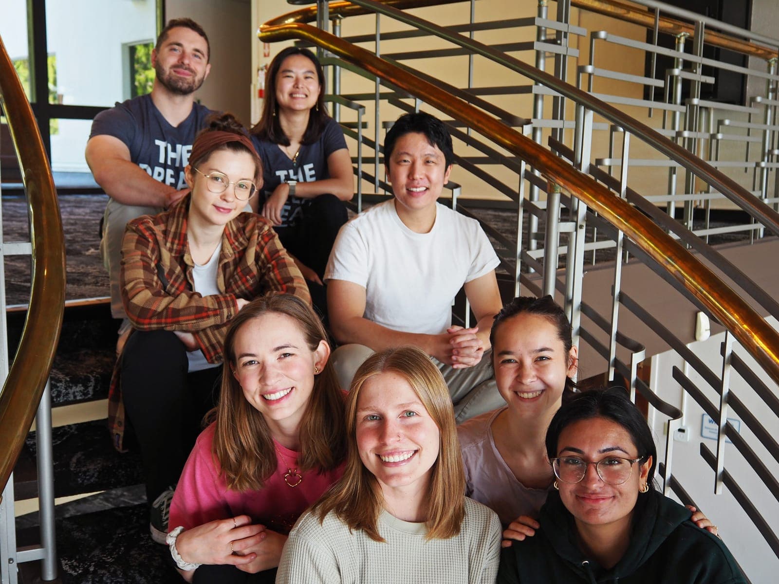 Residents from the class of 2027 smiling together on a curved staircase