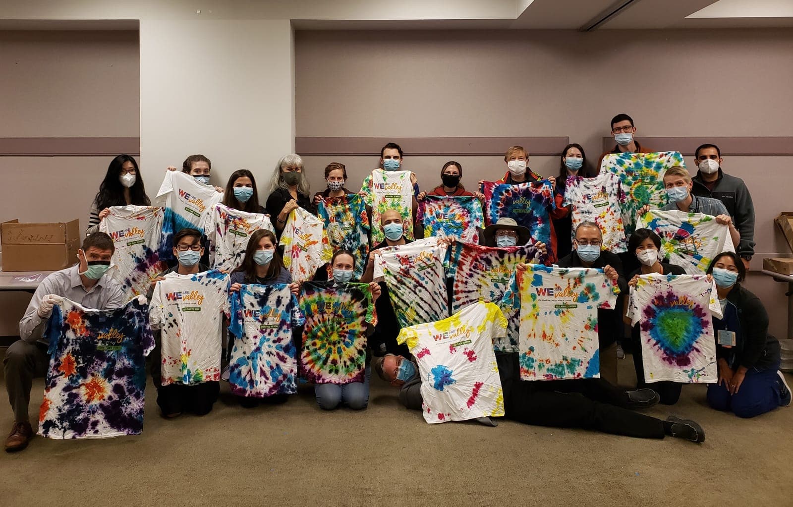 Residents and faculty holding up the tie-dyed shirts they made