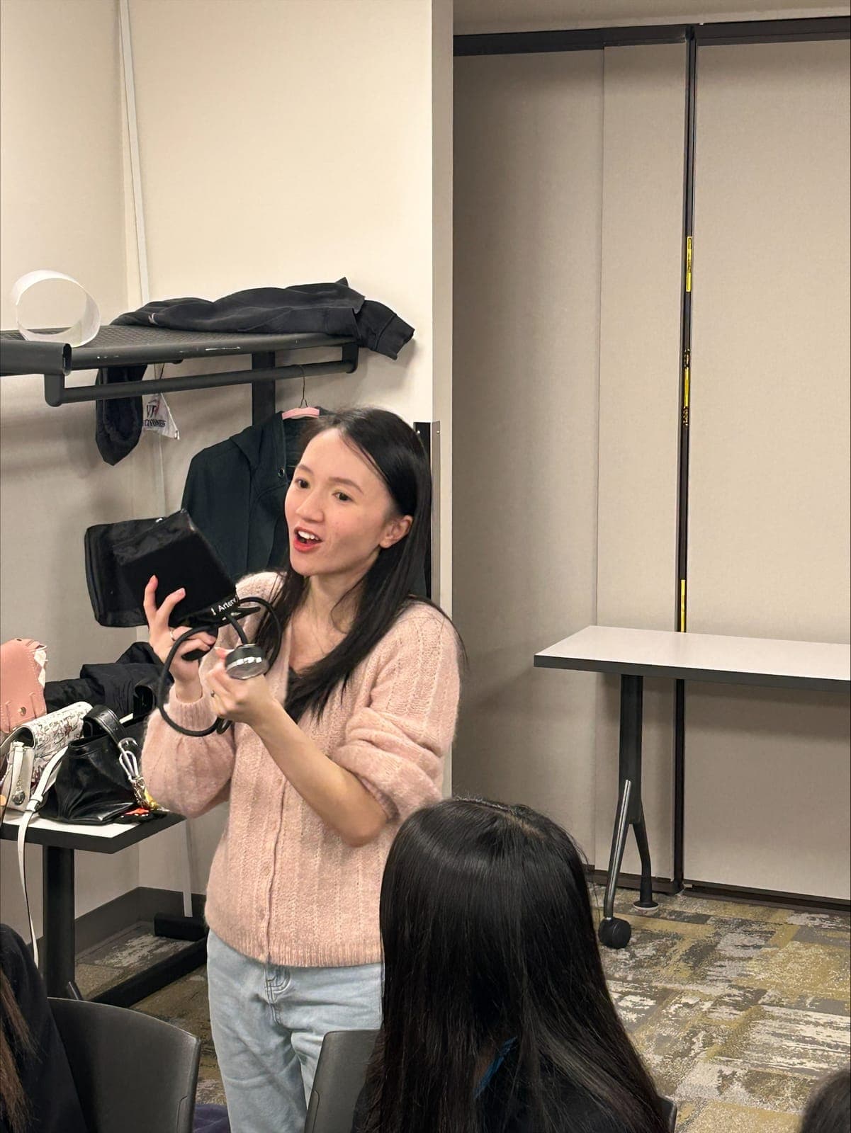 A resident speaking with a microphone to a room of students