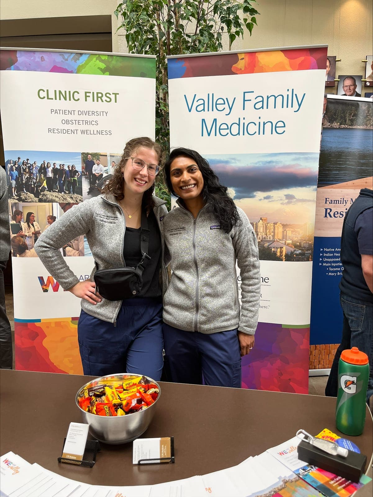 Two residents at the Valley Family Medicine table in front of the program's banners