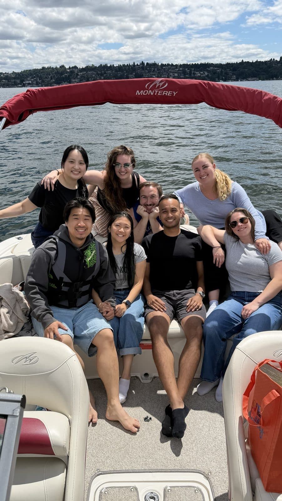 Nine residents from the class of 2029 smiling together at the back of a boat on a lake, with a wooded shoreline behind them