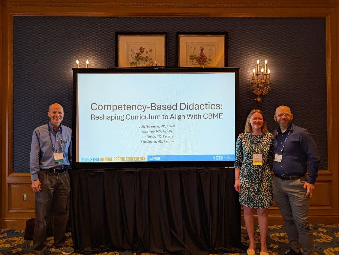 Presenters standing beside a projected title slide at a conference