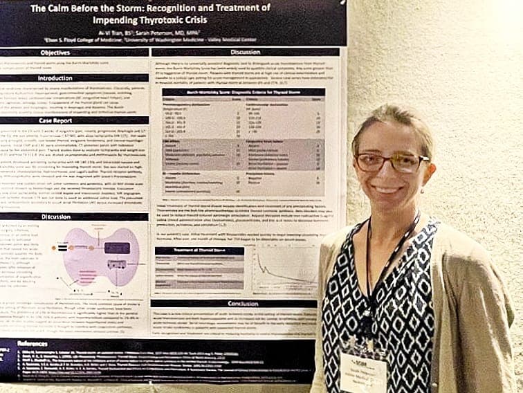 A presenter standing beside a case report poster