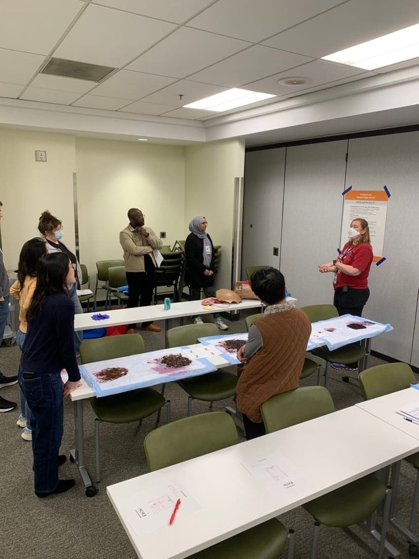 Residents working in small groups at tables set up with simulation models