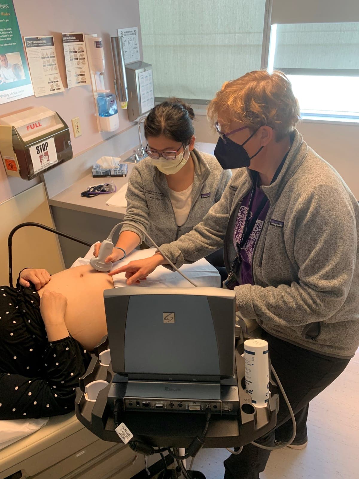 Dr. Dara Jolly guiding a resident through an obstetric ultrasound on a pregnant patient in the OB/GYN clinic